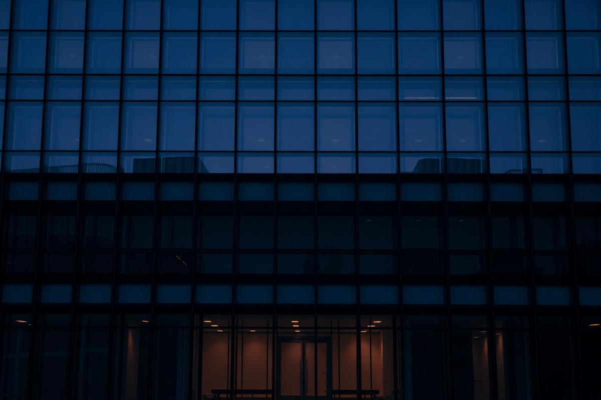 Modern corporate glass architecture at dusk, representing enterprise technology work